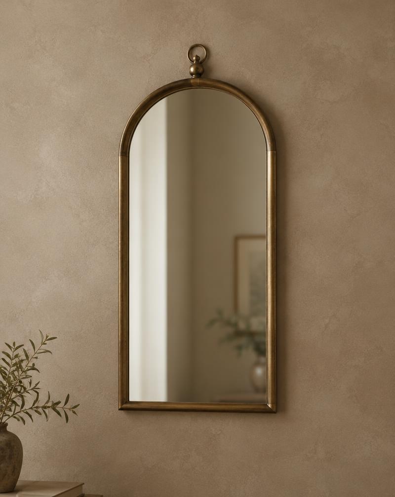 An arched brass mirror